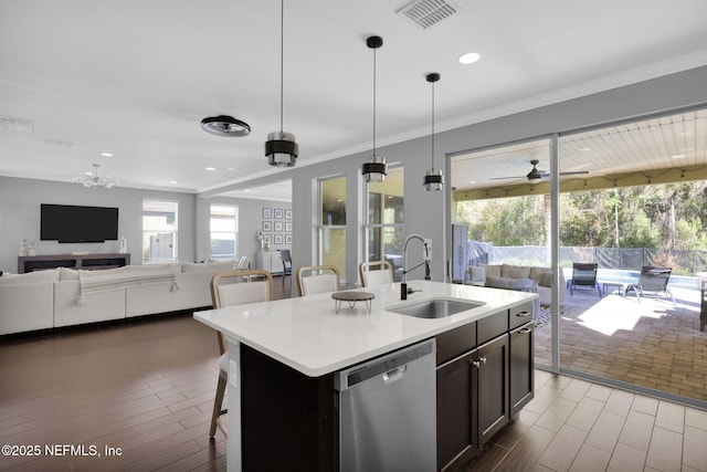 kitchen with sink, dishwasher, hanging light fixtures, a kitchen breakfast bar, and a center island with sink