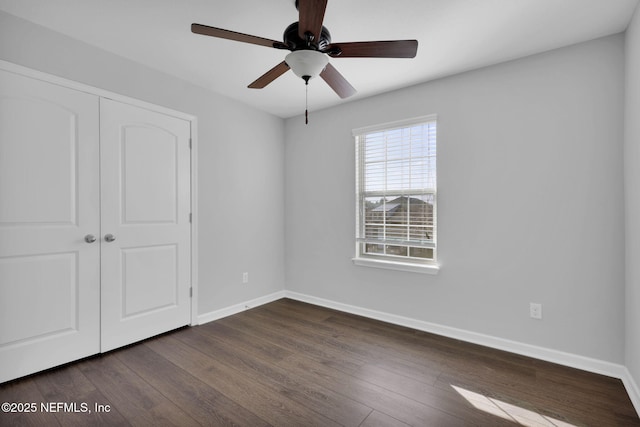 unfurnished bedroom with ceiling fan, dark hardwood / wood-style flooring, and a closet