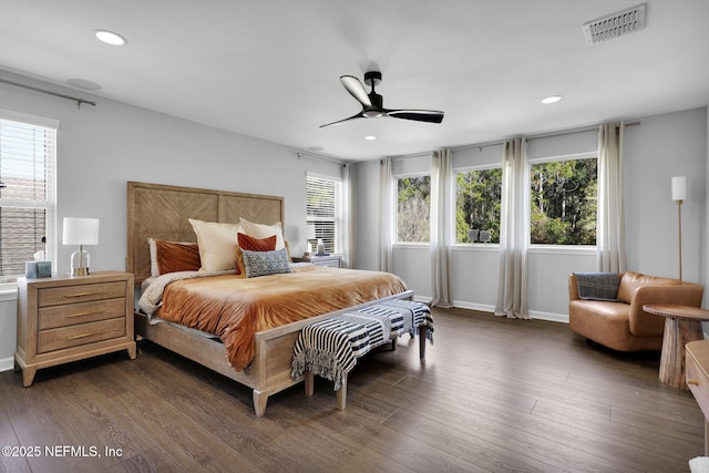 bedroom with dark hardwood / wood-style flooring and multiple windows