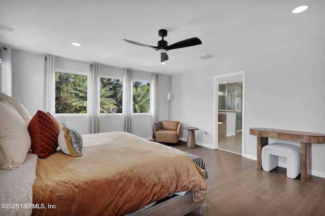 bedroom featuring ceiling fan, ensuite bathroom, and dark hardwood / wood-style floors