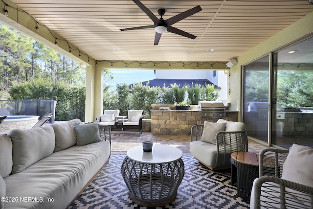 view of patio featuring an outdoor living space, ceiling fan, an outdoor kitchen, and grilling area