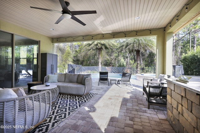 view of patio / terrace featuring outdoor lounge area, exterior bar, and ceiling fan