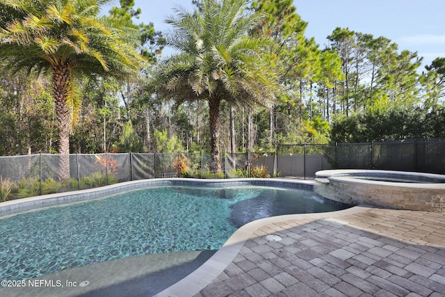 view of pool featuring a patio and an in ground hot tub