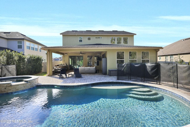 back of property with ceiling fan, an outdoor hangout area, a pool with hot tub, and a patio