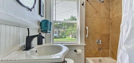 bathroom featuring plenty of natural light, toilet, and shower / bath combo