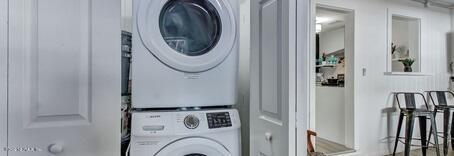 laundry room with stacked washing maching and dryer