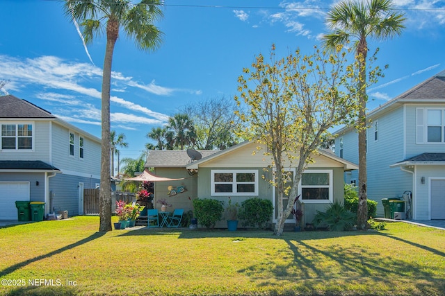 view of property with a garage and a front lawn