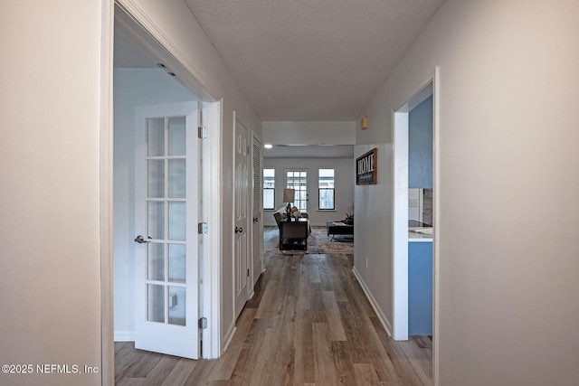 corridor featuring hardwood / wood-style flooring and a textured ceiling