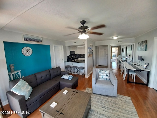 living room featuring sink, hardwood / wood-style floors, and ceiling fan