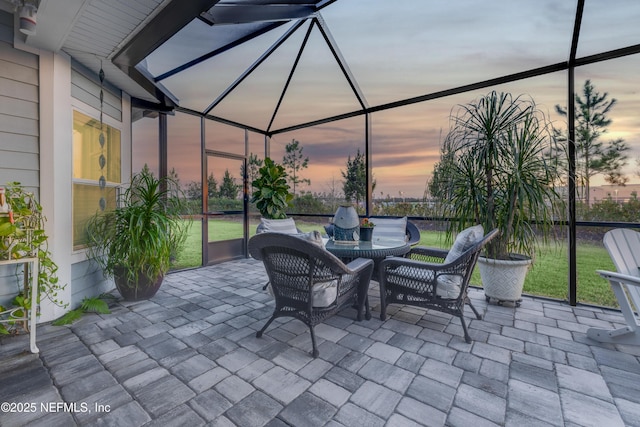 patio terrace at dusk featuring a lanai