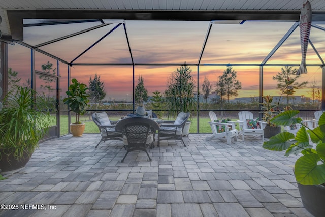 patio terrace at dusk featuring glass enclosure