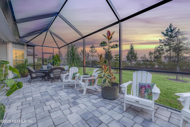 patio terrace at dusk with a yard and glass enclosure