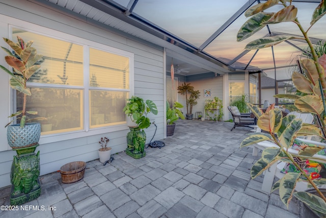 patio terrace at dusk with ceiling fan and glass enclosure