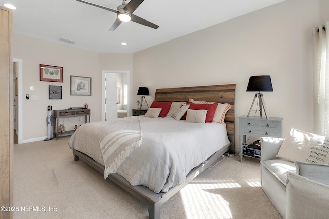 carpeted bedroom featuring ceiling fan and ensuite bath