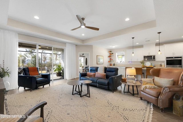 living room featuring a wealth of natural light and a tray ceiling