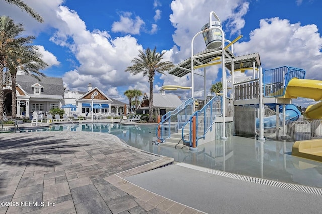 view of pool with a patio, a playground, and a water slide