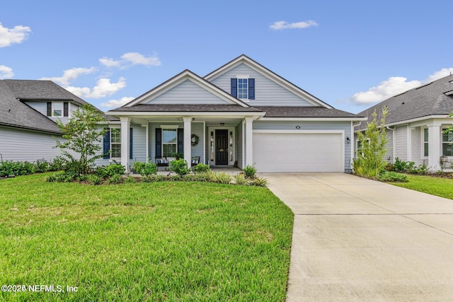 view of front of house with a garage, covered porch, and a front yard