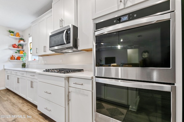 kitchen with white cabinetry, appliances with stainless steel finishes, and light hardwood / wood-style flooring