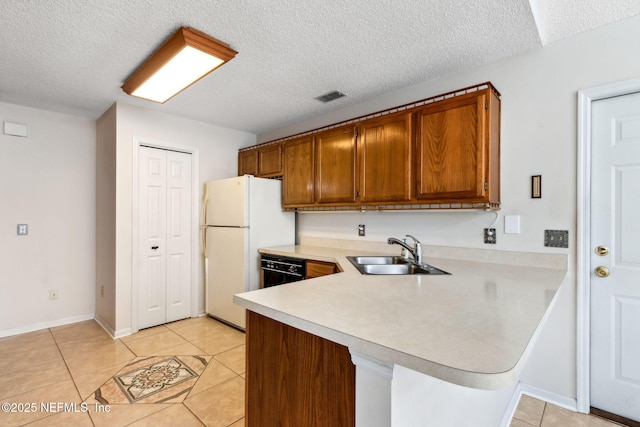 kitchen featuring light tile patterned flooring, sink, a textured ceiling, white refrigerator, and kitchen peninsula