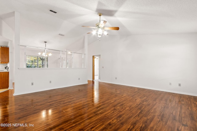 unfurnished living room featuring vaulted ceiling, dark hardwood / wood-style floors, ceiling fan with notable chandelier, and a textured ceiling