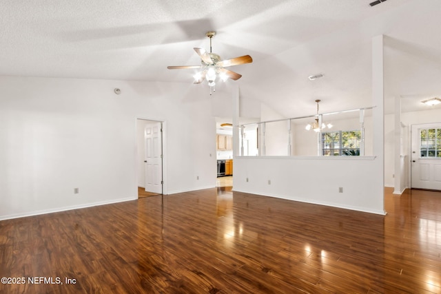 unfurnished living room featuring lofted ceiling, ceiling fan with notable chandelier, a textured ceiling, and dark hardwood / wood-style flooring