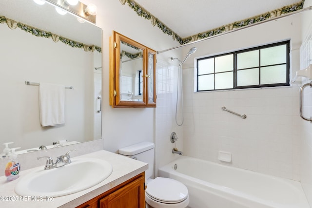 full bathroom featuring tiled shower / bath, vanity, and toilet