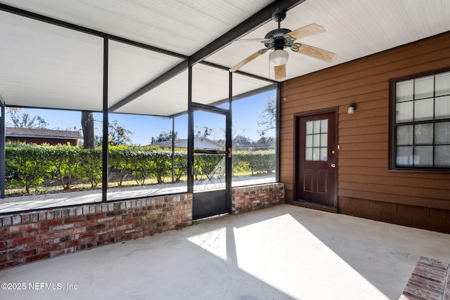 unfurnished sunroom featuring a healthy amount of sunlight and ceiling fan