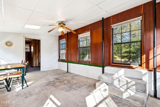 unfurnished sunroom with cooling unit, ceiling fan, and a drop ceiling