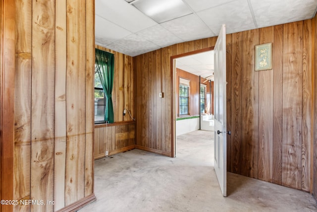 empty room featuring concrete floors and wood walls