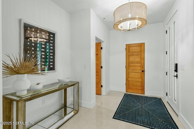 entrance foyer with baseboards and a notable chandelier