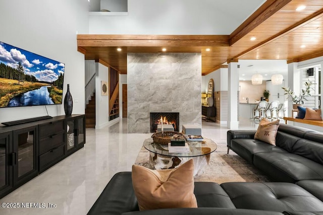 living room featuring stairs, recessed lighting, wooden ceiling, and a premium fireplace