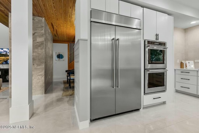 kitchen with wood ceiling, white cabinets, light countertops, appliances with stainless steel finishes, and modern cabinets