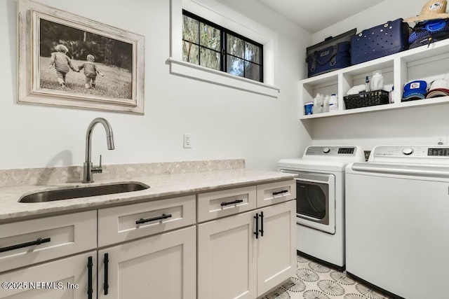 laundry area with cabinet space, a sink, and washing machine and clothes dryer