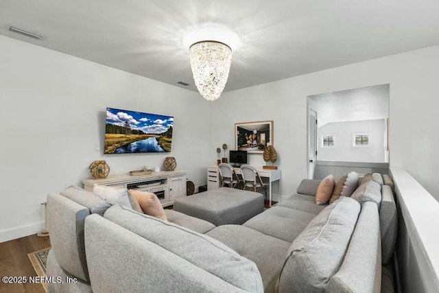 living room featuring baseboards, a notable chandelier, visible vents, and dark wood-style flooring