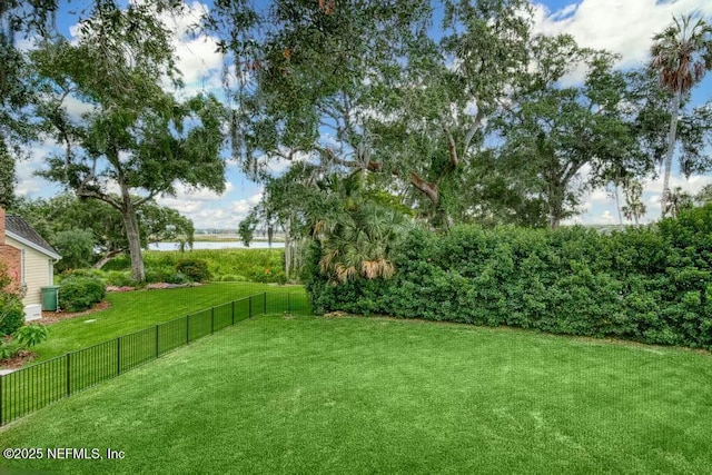 view of yard with a water view and fence