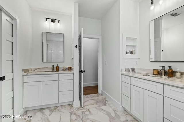 full bathroom featuring marble finish floor, two vanities, visible vents, a sink, and baseboards