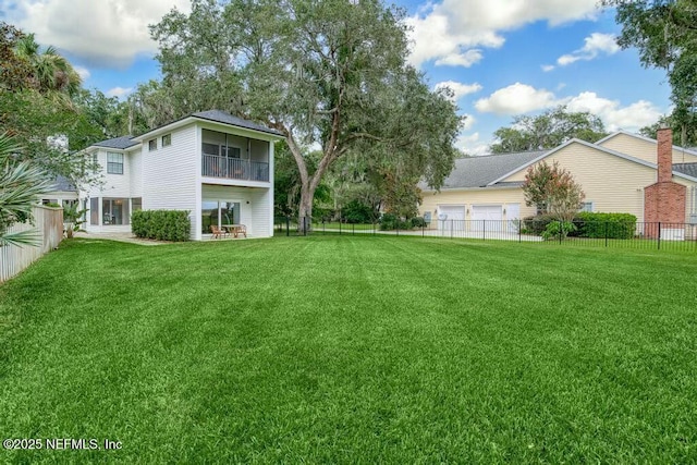 view of yard featuring a garage and a fenced backyard