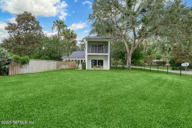 view of yard featuring a fenced backyard and a balcony