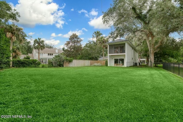 view of yard featuring a sunroom and a fenced backyard