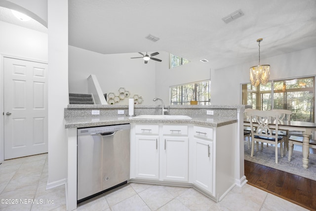 kitchen featuring sink, light stone counters, white cabinets, ceiling fan with notable chandelier, and stainless steel dishwasher