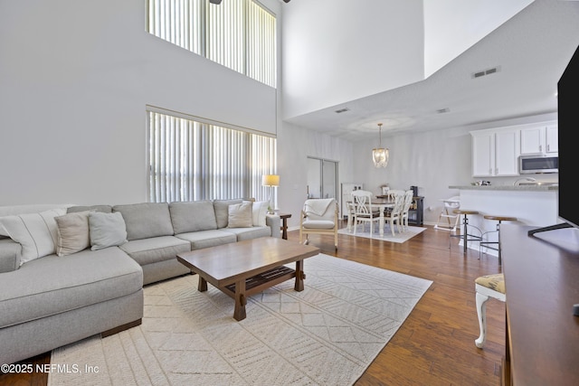 living room with an inviting chandelier and light hardwood / wood-style floors