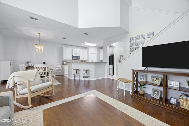 living room featuring a notable chandelier and dark wood-type flooring