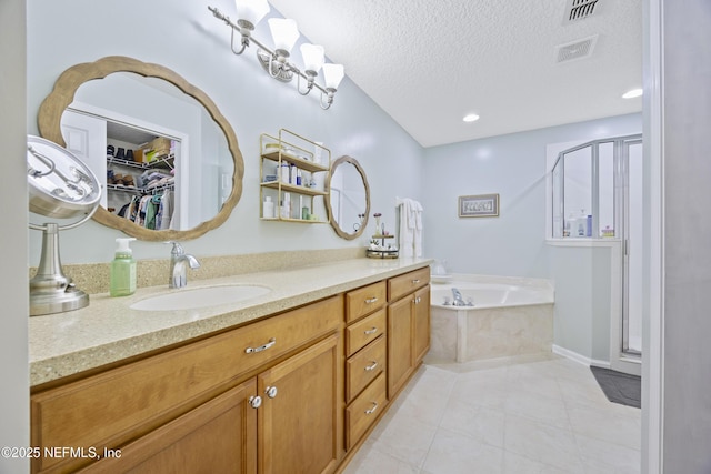 bathroom featuring vanity, tile patterned floors, a textured ceiling, and separate shower and tub