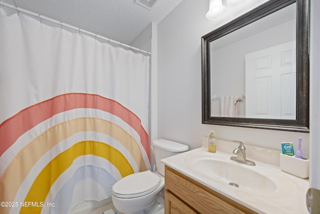 bathroom with vanity, curtained shower, a textured ceiling, and toilet