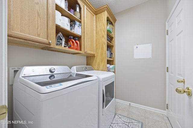 washroom featuring cabinets, separate washer and dryer, and light tile patterned floors