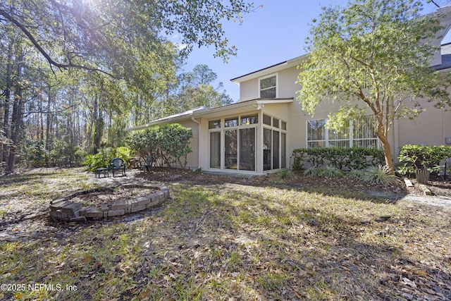 view of yard with a fire pit and a sunroom