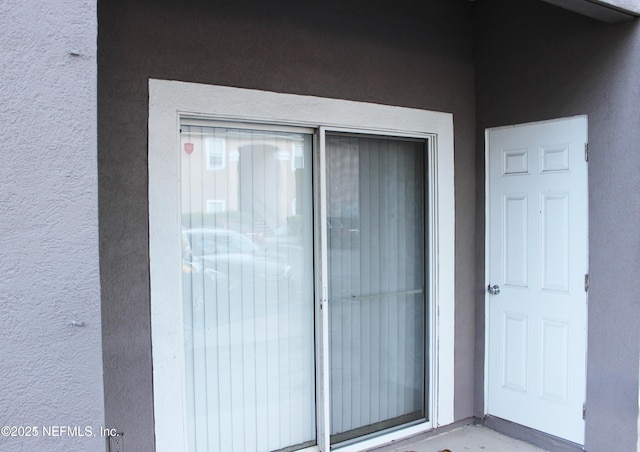 view of exterior entry featuring stucco siding