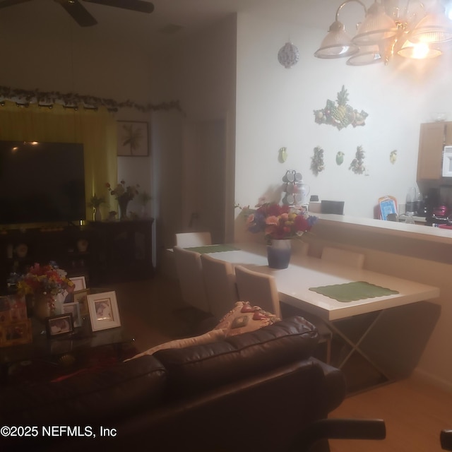 living room featuring ceiling fan with notable chandelier