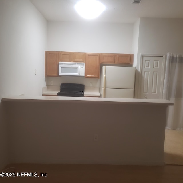 kitchen with light countertops, white appliances, and visible vents