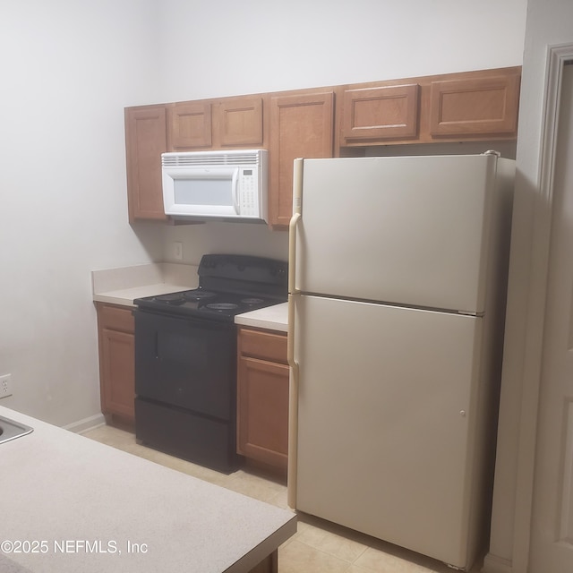 kitchen with brown cabinets, white appliances, and light countertops